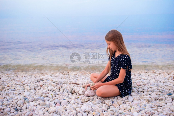 海滨可爱的小女孩在沙滩上玩得开心图片