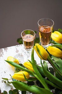 和一杯玫瑰红酒紧贴的黄色郁金奶和一杯玫瑰葡萄酒桌子盛开图片素材