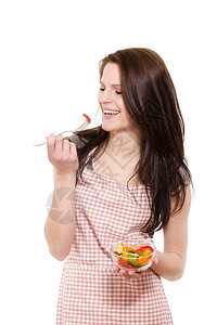 女孩健康笑着吃沙拉的女士快乐年轻女人红色围裙在白背景上吃沙拉漂亮的图片