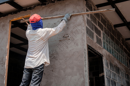 抹刀房间手动的建筑工人使用水泥石膏在建筑墙上打石膏图片