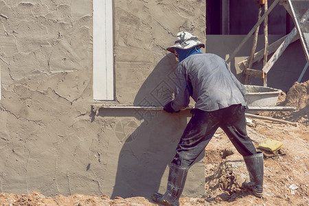 涂层镘建筑工人使用水泥石膏在建筑墙上打石膏房间图片