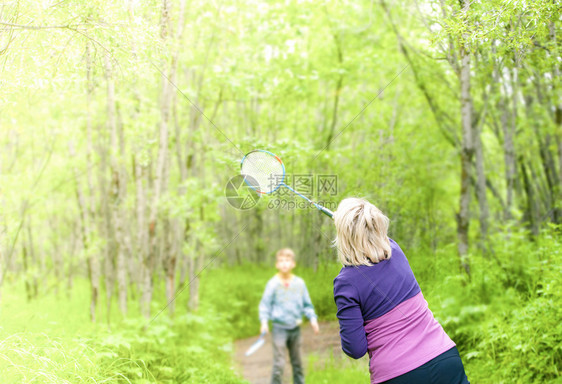 积极的活动微笑在树林里玩羽毛球的女子图片