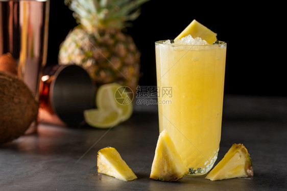石背景中带菠萝椰子和柠檬的鸡尾酒玻璃精稻草图片