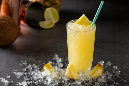 石背景中带菠萝椰子和柠檬的鸡尾酒黄色苏西新鲜图片