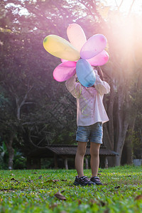 绿色在公园户外露天玩多彩具气球的女童孩肖像自然白色的图片