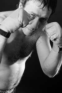 运动粗糙的斗争拳手在战位置上有伤痕的拳击头黑背景图片