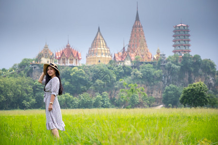 笏站在田和WatThamSua的亚洲妇女美丽泰国图片