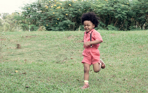 一种朋友们个穿粉红衬衫的非洲男孩正在后院玩休闲的图片