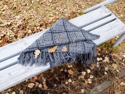 秋天公园长椅上的灰色针织围巾图片