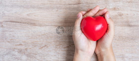 手捧红心预防心脏病概念图片