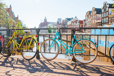 旅行著名的荷兰阿姆斯特丹大桥上的自行车位于荷兰阿姆斯特丹的大桥上荷兰自行车秋季运河的美景结构体图片