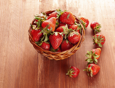 木制背景上带新鲜草莓的篮子木制背景上成熟的草莓健康饮食叶子季节木制的图片