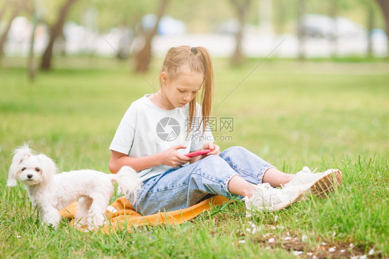 在公园和狗狗休息的小女孩图片
