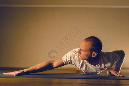 灵从事手臂肌肉工作的年轻男子运动员推高瑜伽在家庭体重上装扮训练浓度苗条的背景图片