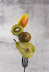 蔬菜液体绿色水果在叉口上切开加水滴和新鲜的果实图片