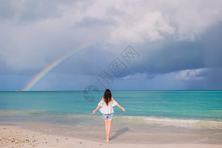 旅行女士美丽的人在海滩上美丽的彩虹在海面上美丽的幸福女人在海滩上美丽的彩虹在海面上夏天图片