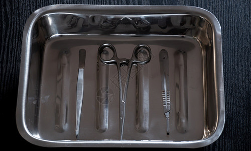 专业的钳子手术刀不锈钢集装箱内容器托盘中的肝力剪刀和敷料器图片