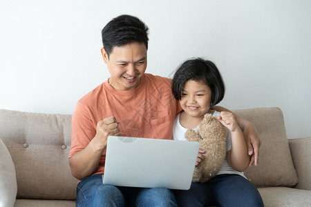 享受一种这个亚洲家庭有一父亲和女儿一个小孩和父亲正在看笔记本电脑他们在家里很快乐他们在家里很开心男人图片