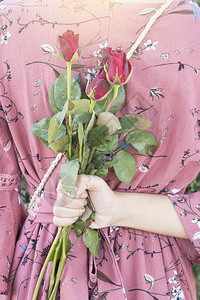 爱中的女人拿着红玫瑰在情人节的给男朋友惊喜花心快乐的图片