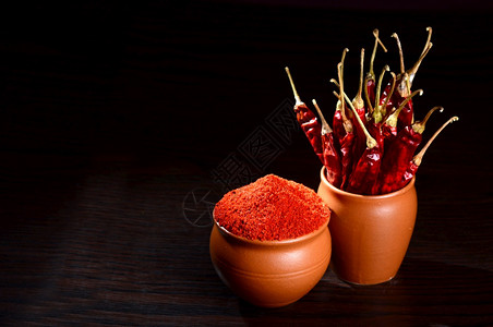烹饪亚洲人粘土锅深底的干冷辣椒粉和红冻热胡椒图片