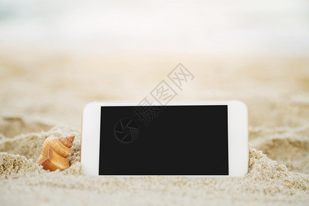 屏幕手机沙滩上带纤维的贝壳假期图片
