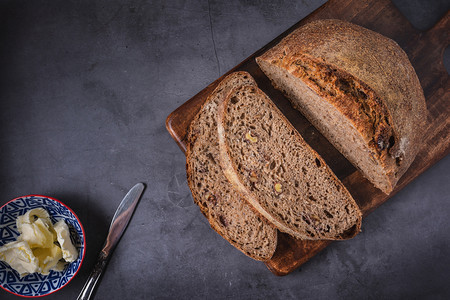 制造燕麦粮食木桌背景上新鲜的青菜面包图片
