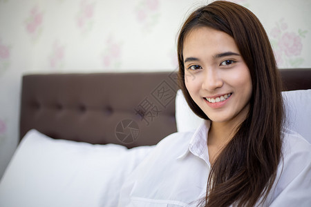 亚洲女人在床上醒来后微笑和快乐枕头的室内图片