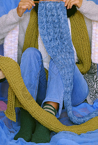 纱年轻的短袜概念女穿着蓝牛仔裤白羊毛衫袜子蓝底的绿羊围巾手工编织制作的预网在空闲时间作为业余爱好冬季取暖图片