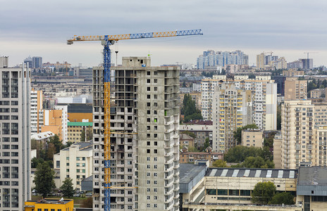 工业的正在建造中房屋现代建筑正在设中塔楼起重机正向上倾斜在修建的现代化混凝土大楼附近有台式起重机和结构体靠近图片