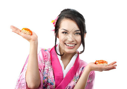 美丽的日本年轻女子用两对棍吃寿司的肖像在白色背景上穿着传统喜莫诺服饰她们穿着白色背景的衣服传统食物白色图片