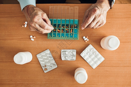 整理药物胶囊的老年人图片