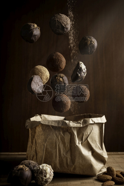 小吃林棕色的由美味漂浮巧克力松露和木本纸袋组成的富有创意摄影作品构成在木背景上图片