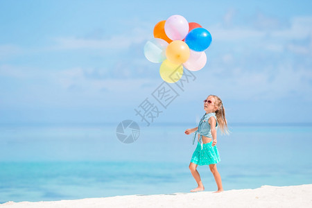 人们乐趣孩子可爱的小女在热带海滩玩气球可爱的小女孩在海滩玩气球图片