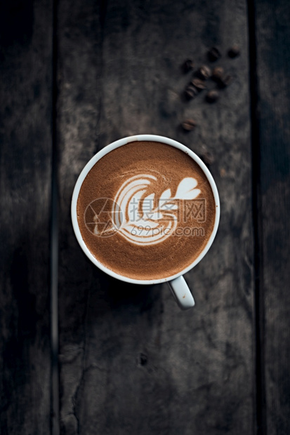 咖啡因爱桌子木制上的热拿铁艺术咖啡重点放在木制桌上的热拿铁艺术咖啡白泡沫杯上图片