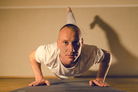 灵活姿势做一个腿子盒的年轻人推上瑜伽在家里装扮训练锻炼图片