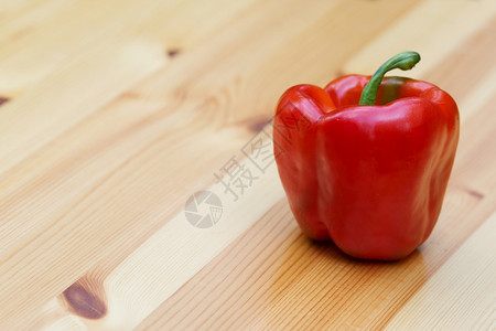 木头制桌顶角的红铃辣椒食物水平的图片