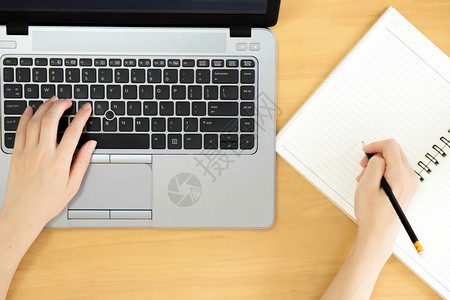 互联网办公室妇女用笔记本电脑空白屏幕和笔记本写字的手女图片