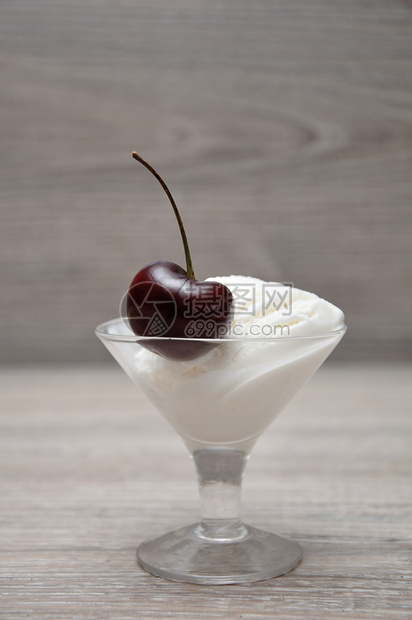 在玻璃碗里一勺冰淇淋上只樱桃可口食物有机的图片