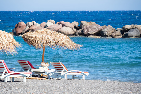 旅行桑托里尼带雨伞和甲板椅的海滩希腊子图片