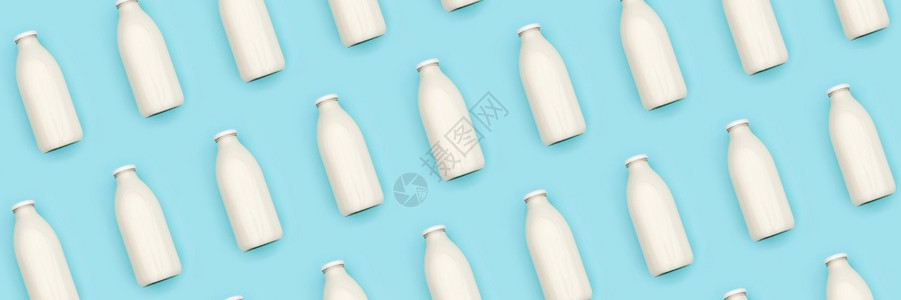 有创造力的蓝色背景透明玻璃瓶牛奶制成的图案平躺顶视横幅蓝色背景透明玻璃瓶牛奶制成的图案平躺顶视横幅蛋白质产品图片