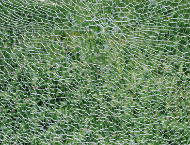 绿色背景上的破碎挡风玻璃损坏的质地锋利图片