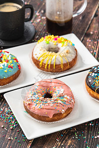 丰富多彩的粉色蜜糖美味甜圈装饰木制桌上有各种装饰品图片