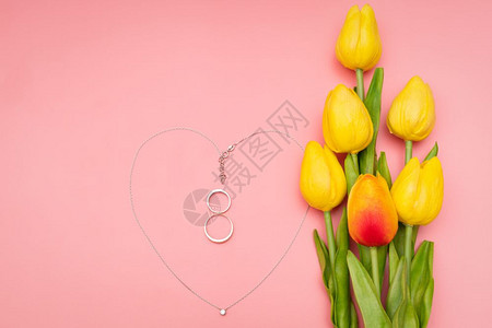 庆祝母亲浪漫国际妇女节花朵和心形项链粉红背景的鲜花和心形项链图片