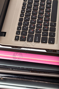 不同的数字报告用不同颜色和型号的旧笔记本电脑堆放不同颜色和型号的旧笔记本电脑用于修理和服务图片