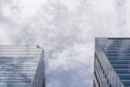 城市的未来派高蓝色天空和白云的大玻璃办公楼图片