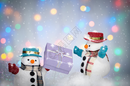 黑色的冬天下雪背景中的人和礼品盒AF点选择和制作雪花散景图片