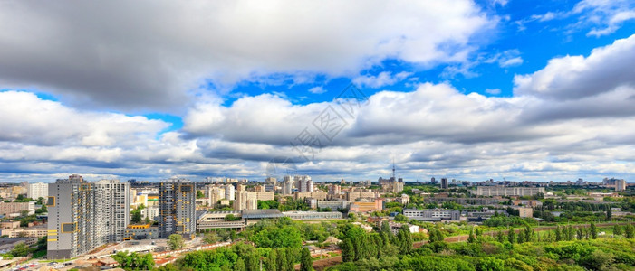 天空城市景观晴在阳光明媚的城市上有高的公寓楼和绿色园全景城市风和地平线全大低云层和明光的城市景色图片