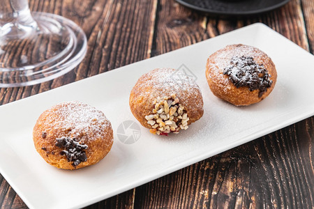 Bombolone或bomboloni是意大利填满甜圈和零食的意大利品德国甜圈克拉芬或贝林机装满果酱和巧克力甜点美食抛光图片