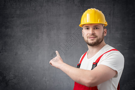 职业男人建筑工指着墙对面水平的图片