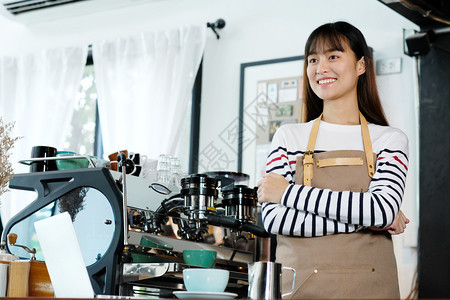 专业的年轻女亚洲会员在咖啡馆柜台背景小商业主食品和饮料业概念的字体中微笑地站着面脸机器在室内图片